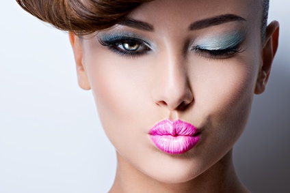 Closeup face of beautiful flirting woman with fashion bright vivid color eye makeup